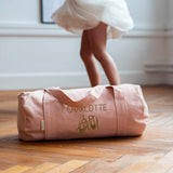 sac de sport rose poudré personnalisé, posé au sol pendant le cour de danse d'une petite fille
